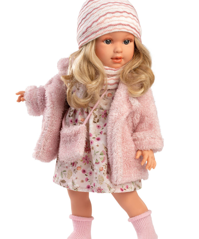 Doll wearing a pink coat, floral dress, and striped hat on a white background