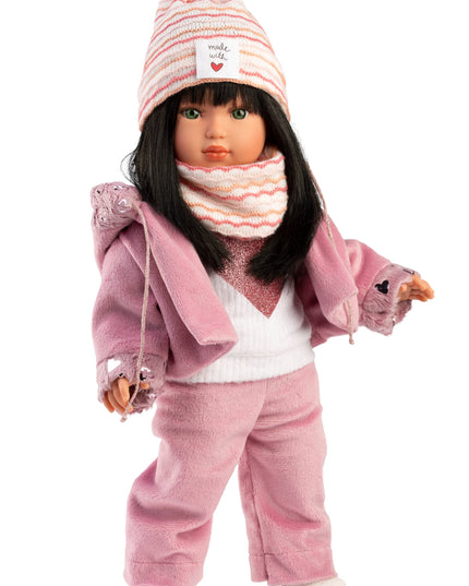 Doll wearing a pink outfit with a hat and scarf on a white background