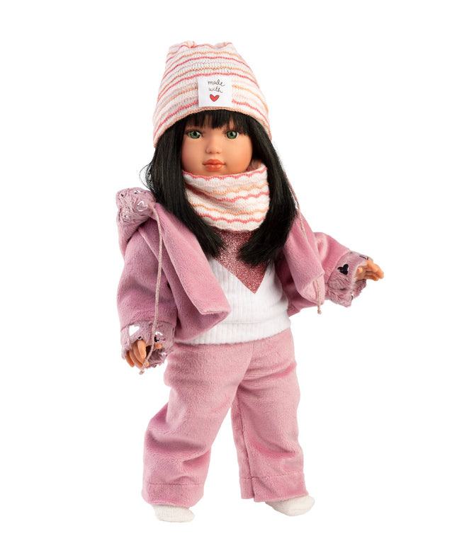 Doll wearing a pink outfit with a hat and scarf on a white background