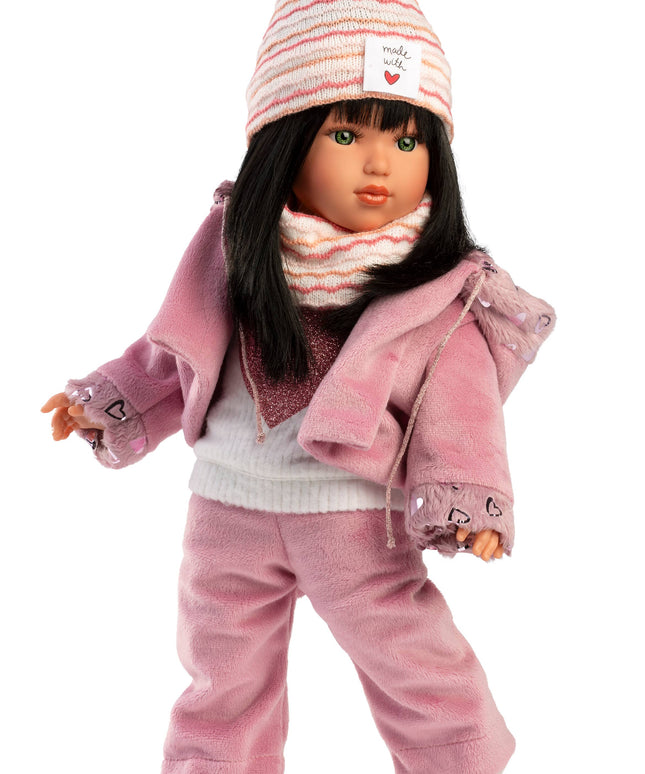 Doll wearing a pink outfit with a matching hat on a white background