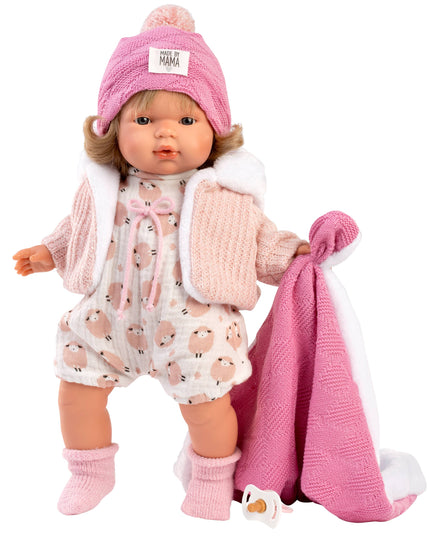 Doll in pink outfit with hat and blanket on a white background