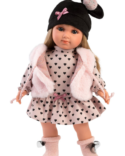Doll wearing a black hat with a pink bow, heart-patterned dress, and pink coat on a white background