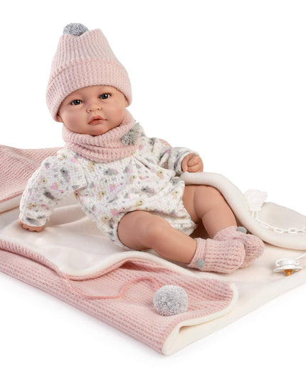Baby doll wearing a pink outfit with a matching hat on a white background