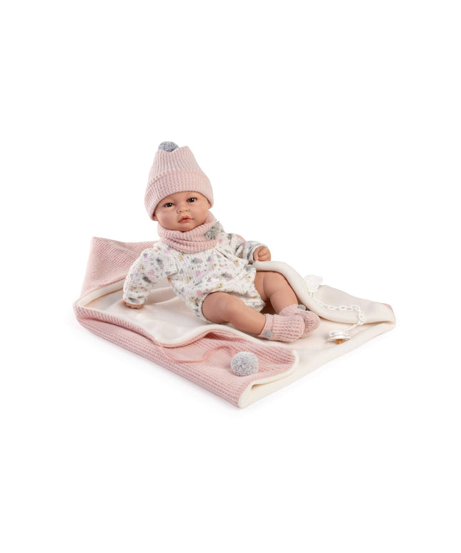 Baby doll wearing a pink outfit with a matching hat on a white background