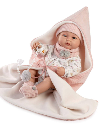 Baby doll wrapped in a pink blanket with a white background