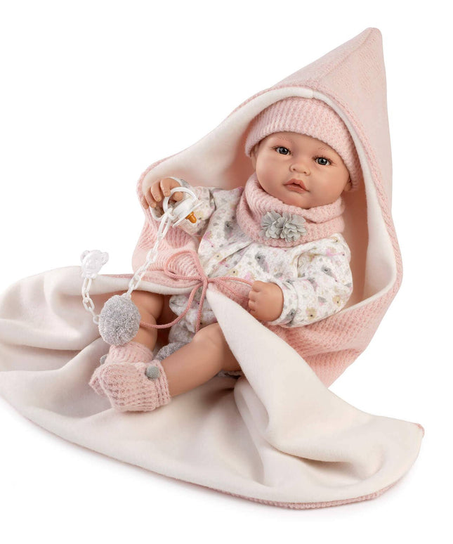 Baby doll wrapped in a pink blanket with a white background