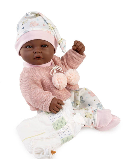 Baby doll in pink outfit with floral hat on a white background