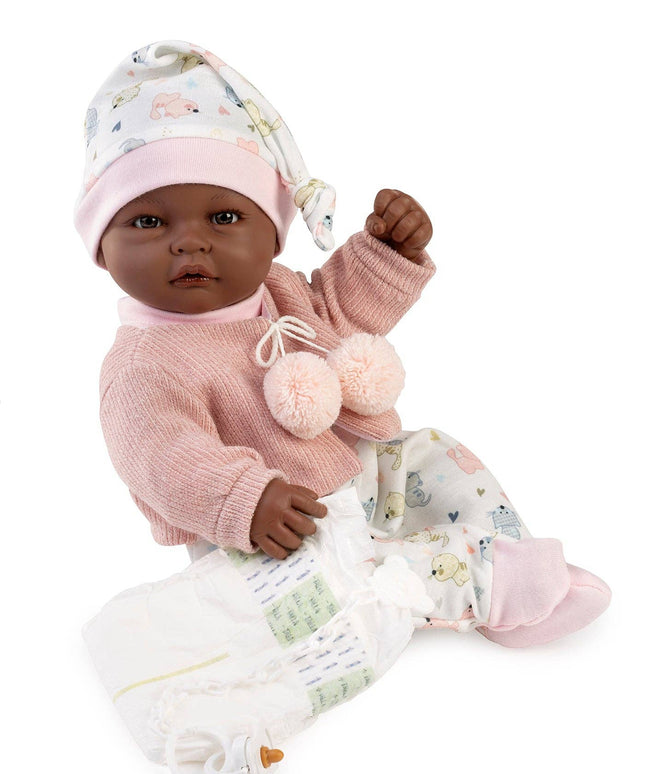 Baby doll in pink outfit with floral hat on a white background