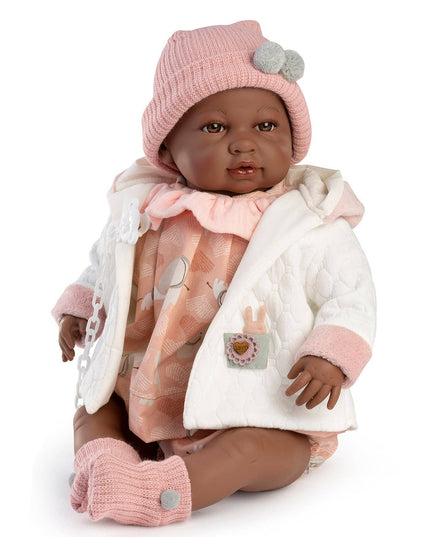 Baby doll wearing a pink hat, white coat, and pink pants on a white background