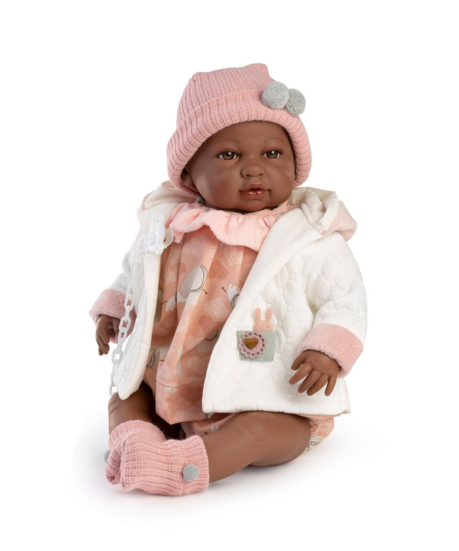 Baby doll wearing a pink hat, white coat, and pink pants on a white background