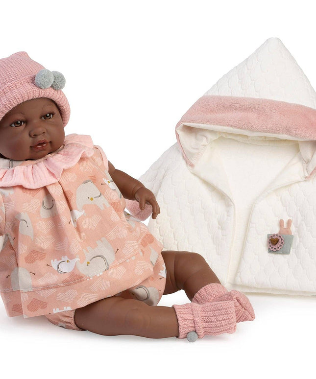 Baby doll with pink outfit and white jacket on a white background