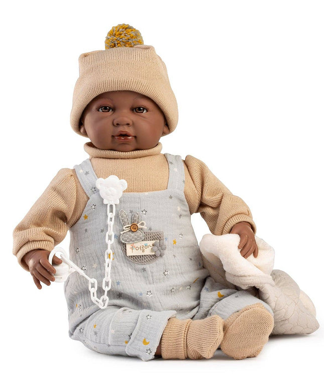 Baby doll with gray overalls and beige hat on a white background