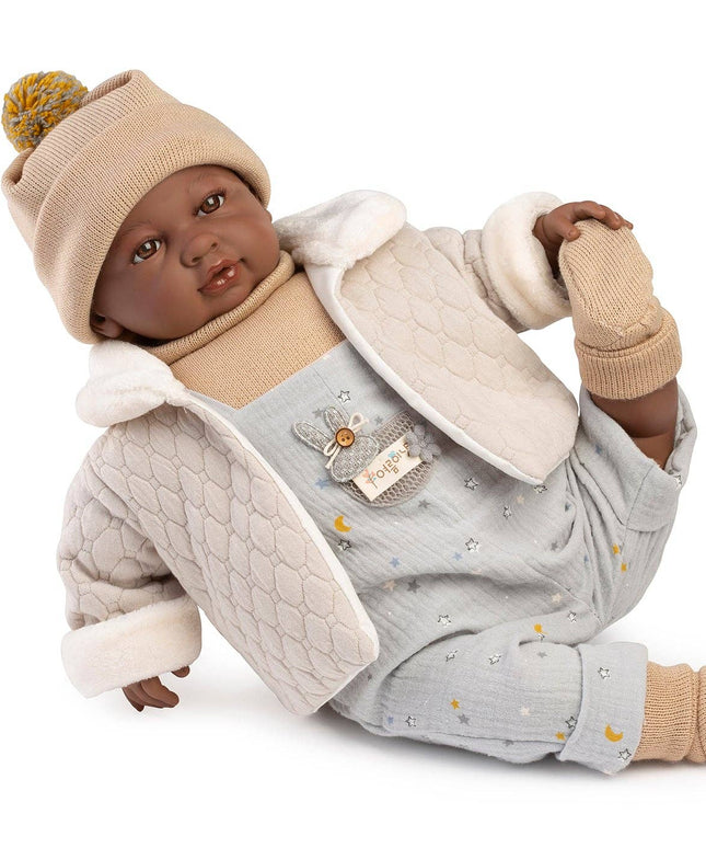 Baby doll wearing a coat, hat, and gloves on a white background