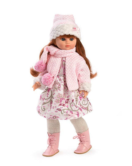 Doll wearing a pink winter outfit with a coat, scarf, hat, and boots on a white background