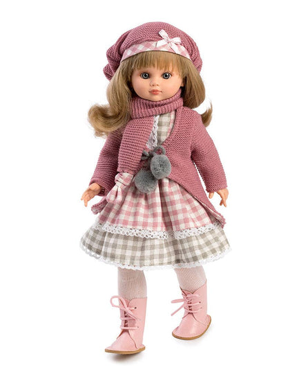 Doll wearing a pink outfit with a checkered skirt on a white background
