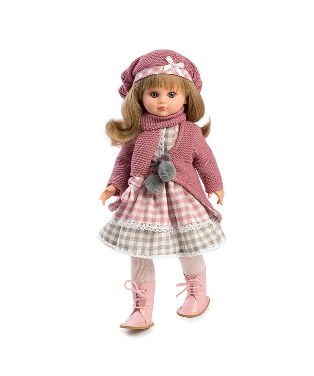 Doll wearing a pink outfit with a checkered skirt on a white background