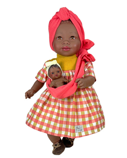Doll wearing a red checkered dress holding a smaller doll on a white background