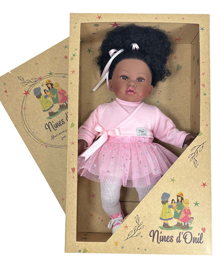 Doll in a pink outfit with a white bow in a cardboard box, branded 'Nines d'Oril'.
