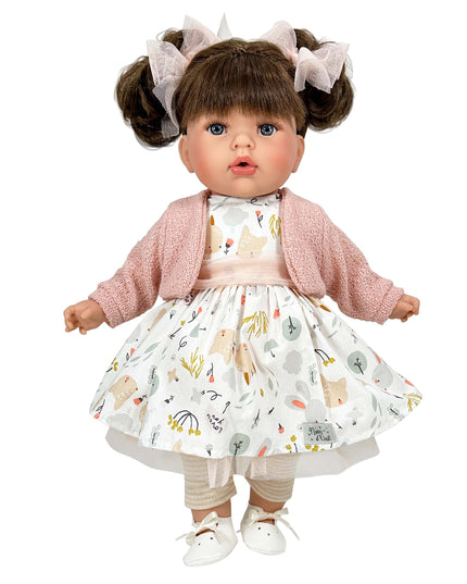 Doll wearing a pink cardigan and patterned dress on a white background