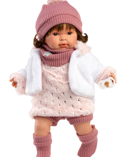 Doll wearing a pink outfit with a hat, scarf, and boots on a white background