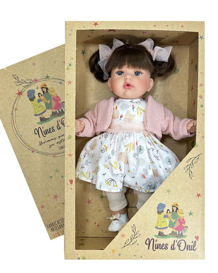Doll in a box with 'Nines d'Oril' branding on a white background