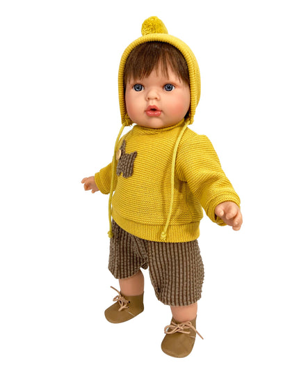 Baby doll wearing a yellow knitted outfit with a hood on a white background