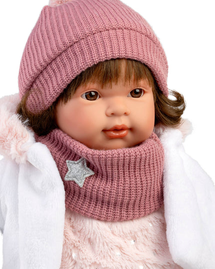 Child wearing a pink knitted hat and scarf with a white coat on a white background