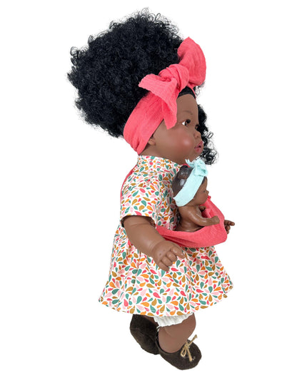 Doll with curly hair wearing a colorful dress and pink headband on a white background