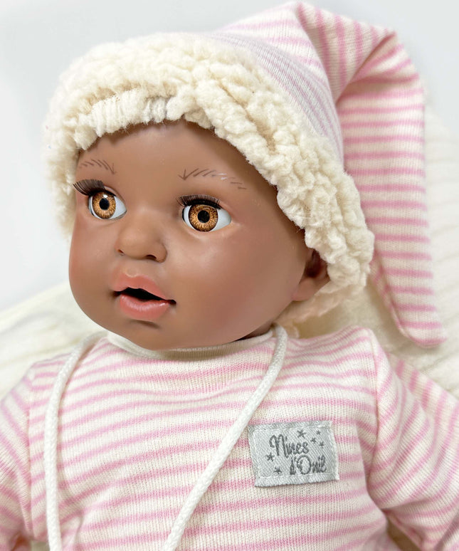 Baby doll with pink and white striped outfit and hat on a light gray background