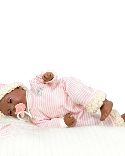 Baby doll in pink outfit with white trim on a white background