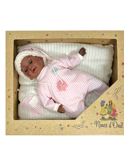 Baby doll in a pink outfit with a white blanket inside a decorative box, featuring the brand 'Nines d'Oril'.