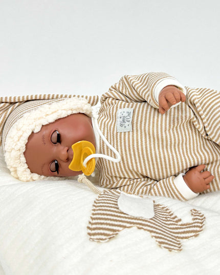 Baby doll in a striped outfit with a pacifier on a white background