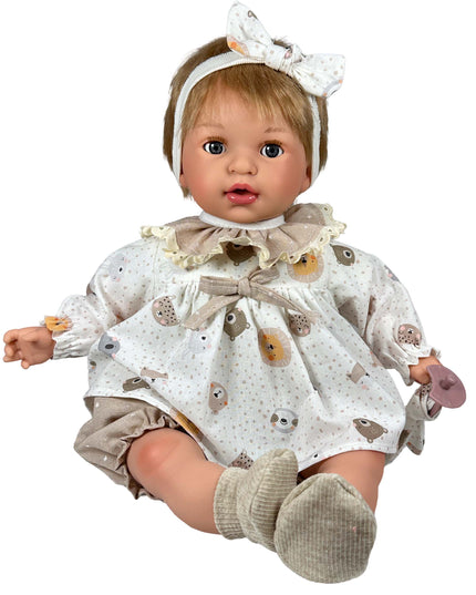 Baby doll wearing a patterned outfit with a bow headband on a white background