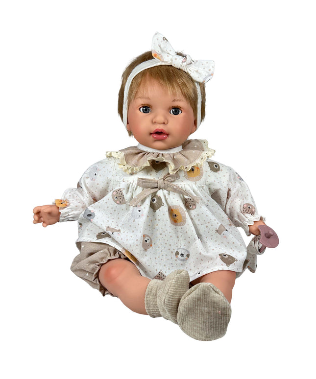 Baby doll wearing a patterned outfit with a bow headband on a white background