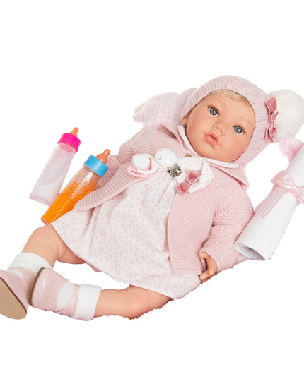 Baby doll in pink outfit with accessories on a white background