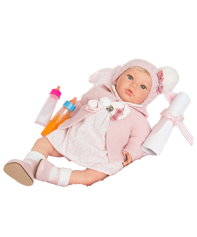 Baby doll in pink outfit with accessories on a white background