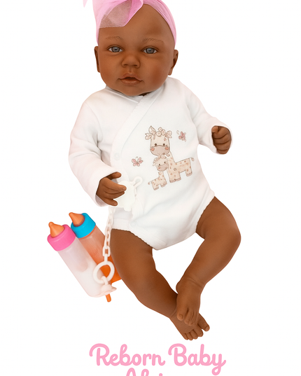 Reborn baby doll in a white onesie with a pink headband, holding a bottle and pacifier, on a white background.