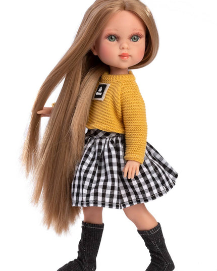 Doll with long brown hair wearing a yellow sweater and black and white checkered skirt on a white background