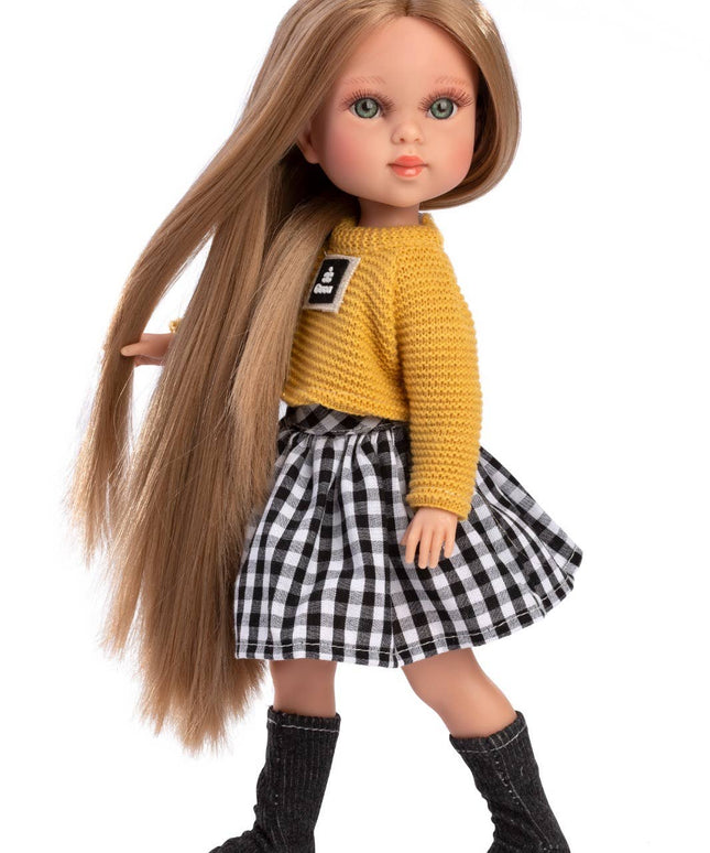 Doll with long brown hair wearing a yellow sweater and black and white checkered skirt on a white background
