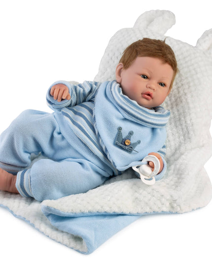 Baby doll in a blue outfit with a white blanket on a white background