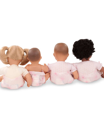 Four dolls with different hair colors sitting together on a white background