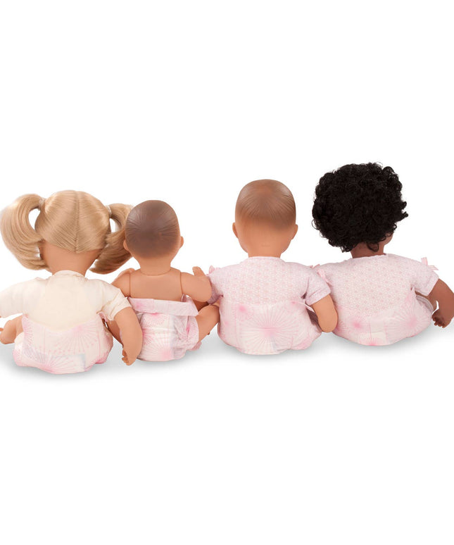 Four dolls with different hair colors sitting together on a white background
