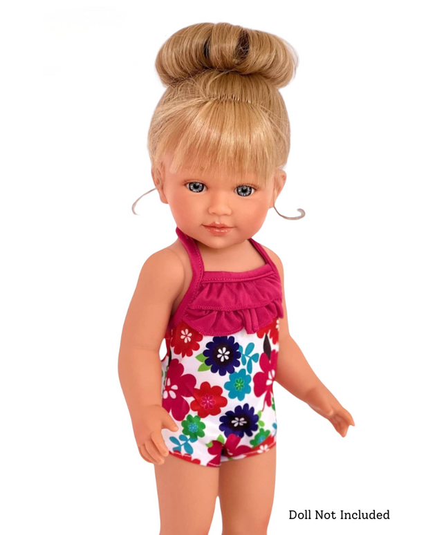 Doll wearing a floral swimsuit with a pink top on a white background