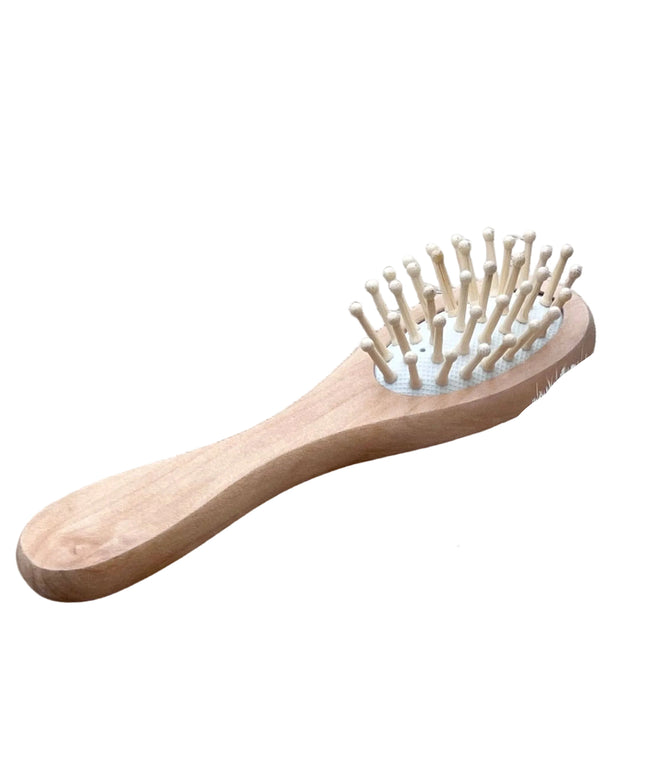 Set of wooden grooming tools including a brush, scrubber, and comb on a wooden surface.