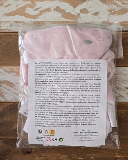 Pink baby outfit in clear packaging with a label on a wooden surface