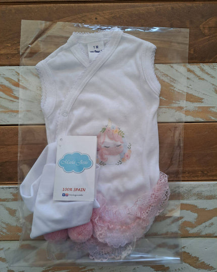 Baby outfit with white sleeveless top, pink socks, and lace details on a wooden surface.