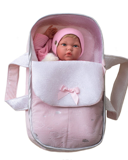 Baby doll in a pink and white baby carrier on a white background
