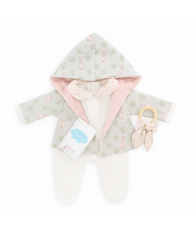 Baby hooded cloak with pink lining and a teething ring on a white background