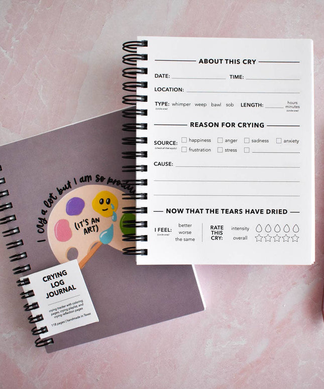 Crying log journal with a pen on a pink background