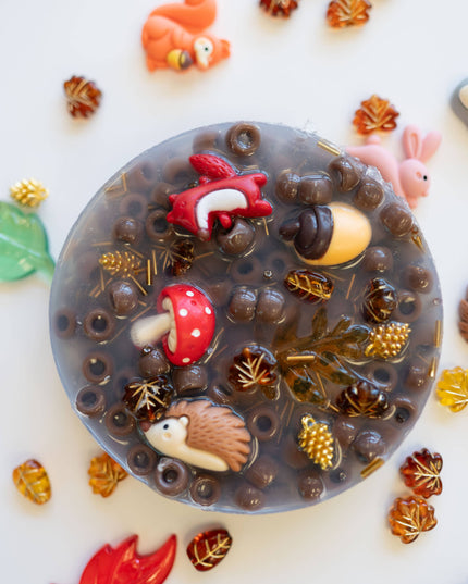 Decorative soap with animal figurines and nature elements on a white background